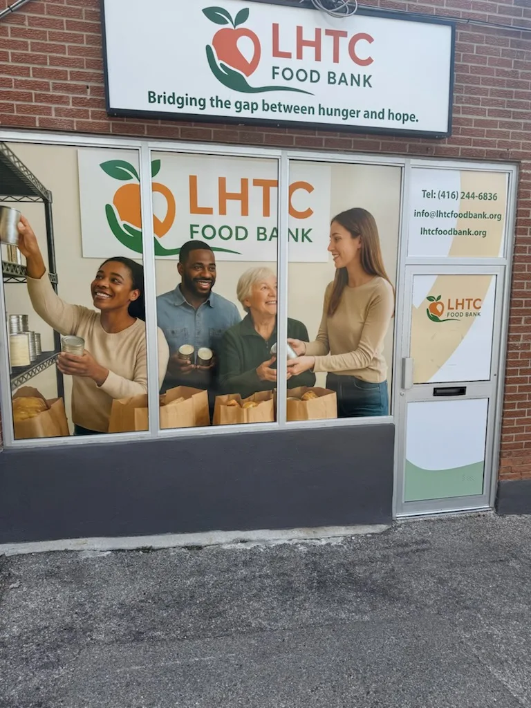 The front of LHTC Food Bank on Weston Rd: the apple logo sign on red brick above the storefront window and door